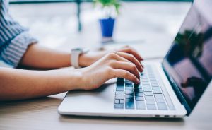 Hands typing on a laptop.
