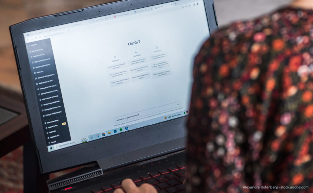 Woman on laptop with artificial intelligence tool, ChatGPT, on screen.