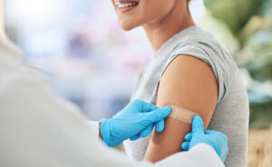 Female getting bandaid after receiving booster shot.